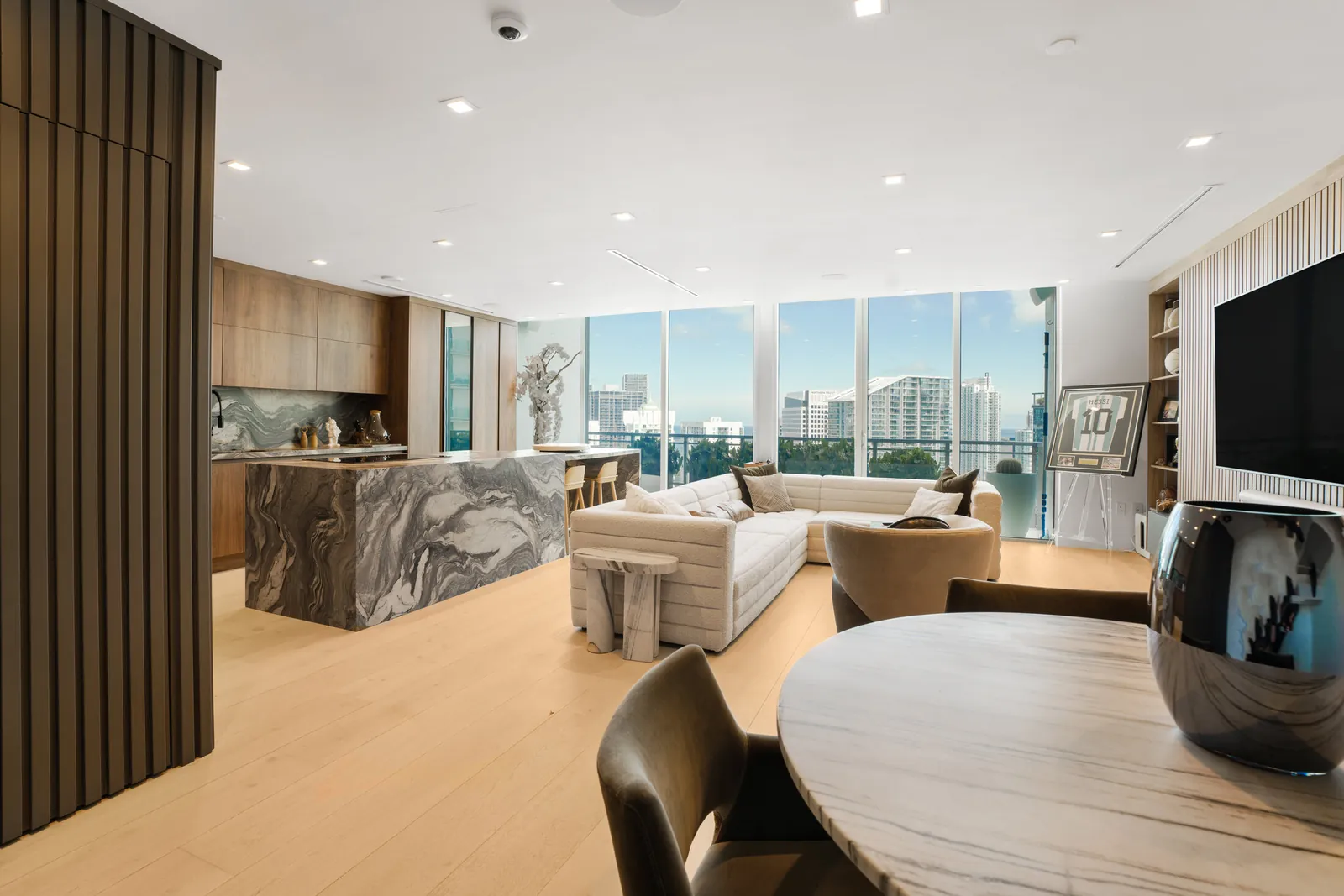 Open living room and marble kitchen island with floor-to-ceiling windows over Brickell